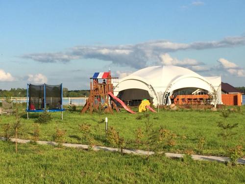 a large tent with a playground in a field at Paluba Hotel in Kalyazin