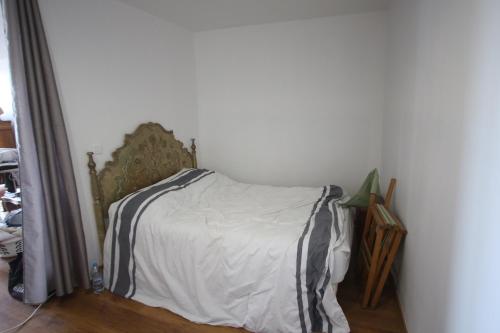 a bedroom with a bed with a white and black sheets at Super appartement avec belle luminosité en plein centre ville de Sisteron in Sisteron