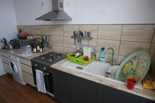 a kitchen counter with a sink and a stove at Super appartement avec belle luminosité en plein centre ville de Sisteron in Sisteron