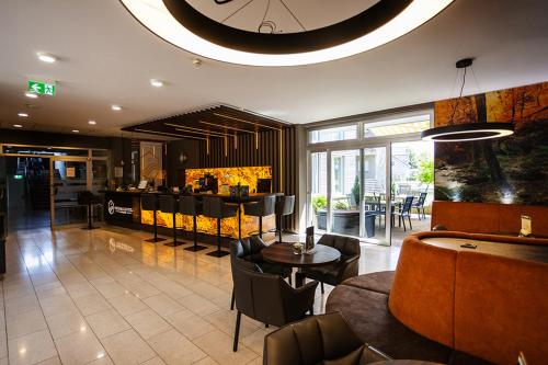 a lobby with a restaurant with a table and chairs at Thermalhotel Kemper in Erwitte
