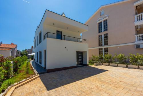 a large white house with a driveway at House Neptunia in Medulin