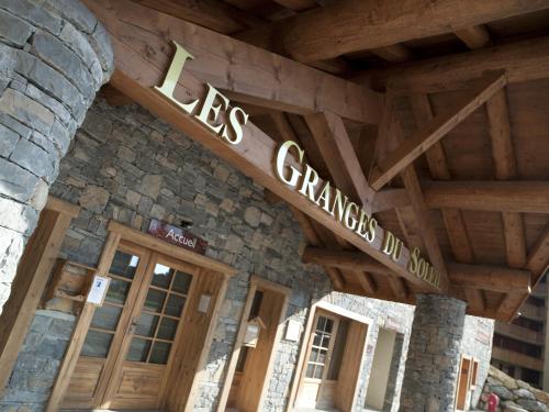 a building with a sign that reads lgs grange village at CGH Résidences & Spas Les Granges Du Soleil in La Plagne