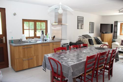 une cuisine et une salle à manger avec une table et des chaises dans l'établissement LA CHAUMIERE DE TAVOU, à Cornimont