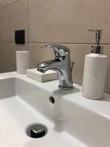 a sink with a faucet and a roll of paper towels at Corallo Neroo in Milazzo
