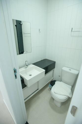 a white bathroom with a sink and a toilet at Porto Star Prime By AFT in Porto De Galinhas