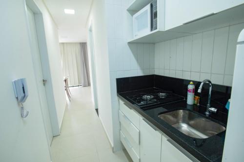 uma pequena cozinha com um lavatório e um fogão em Porto Star Prime By AFT em Porto de Galinhas
