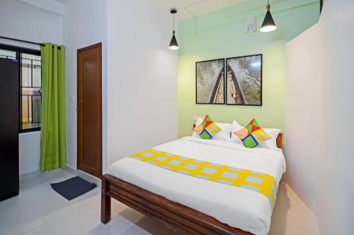 a bedroom with a bed and a window at OYO Home Pop Tavern Pettah in Chacka