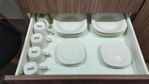 a cabinet with white plates and cups in it at Lovely and Peaceful Home in Guatemala