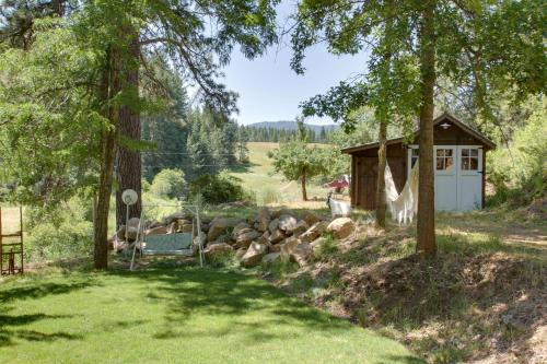 a cabin with a bench in a yard with trees at Modern Farmhouse with Movie Room - 6 Mi to Lake! in Coeur d'Alene