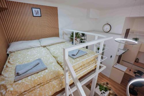 1 dormitorio con litera y reloj en Greenlight Gallery by NeWave Apartments, en Budapest