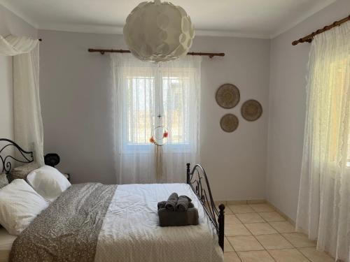 Un dormitorio con una cama con dos zapatos. en Yiayia Katina’s House, en Korinthos