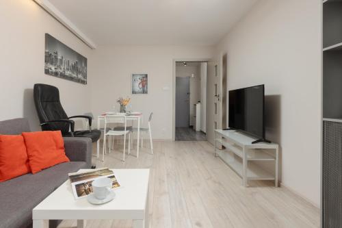 uma sala de estar com um sofá e uma televisão em Pet-Friendly Apartment in City Center by Renters em Varósvia