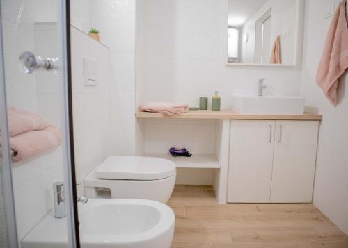 ein weißes Bad mit einem WC und einem Waschbecken in der Unterkunft Hortensia in Buje