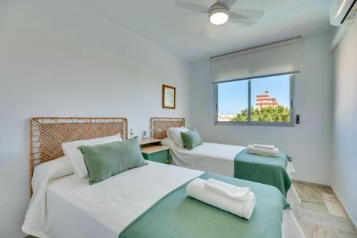 een slaapkamer met 2 bedden en een raam bij VB Myramar 2BDR Sun & Calm in Benalmádena