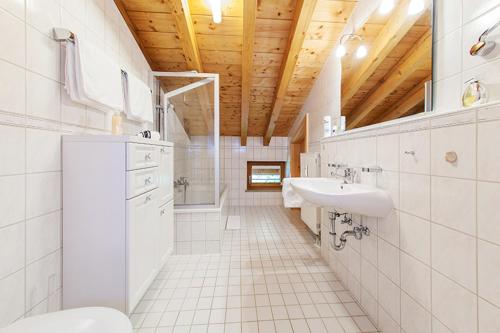 a white bathroom with a sink and a toilet at Chalet Weißlofer in Reit im Winkl