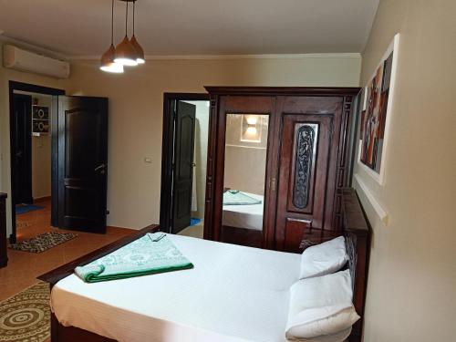 a bedroom with a large bed and a mirror at Porto Marina Rental in El Alamein