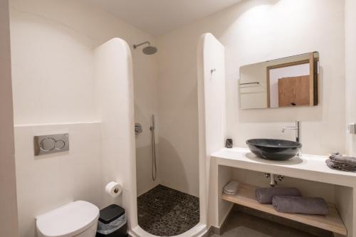 a white bathroom with a sink and a toilet at Sand Gem - Beach Apartments in Perivolos