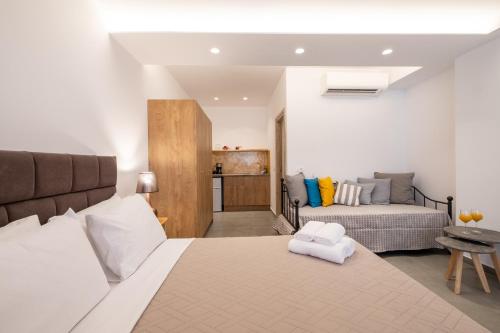 a bedroom with a bed and a couch in a room at Sand Gem - Beach Apartments in Perivolos