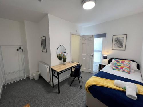 a bedroom with a bed and a desk in it at Stay @ The Wellington, Burton On Trent in Burton upon Trent