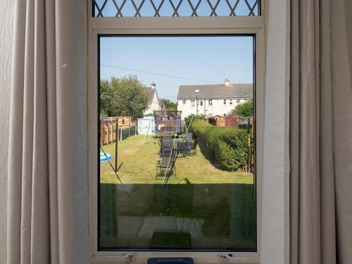 a window with a view of a yard at Pass the Keys Private Entrance GF 2 bed flat near Renfrew Centre in Renfrew