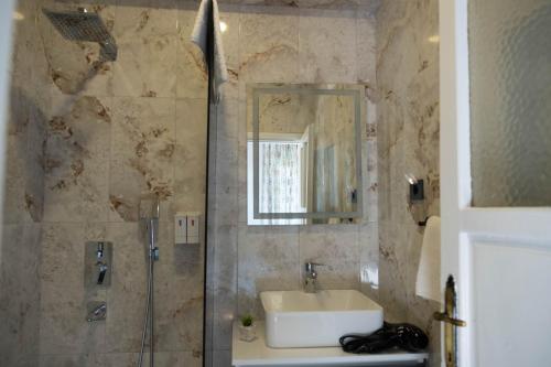 a bathroom with a sink and a shower with a mirror at Kibele Hotel in Oludeniz