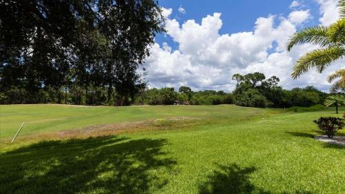 a golf course with a palm tree and a green field at 974 Rotunda in Rotonda West