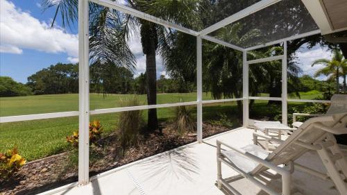 a porch with a chair and a view of a golf course at 974 Rotunda in Rotonda West