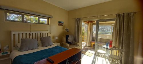een slaapkamer met een bed en een glazen schuifdeur bij Glencairn Vista in Kaapstad