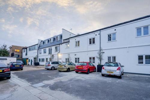 ロンドンにあるSouthwark & City Apt 3Bの建物横の駐車場に停車する車の集団