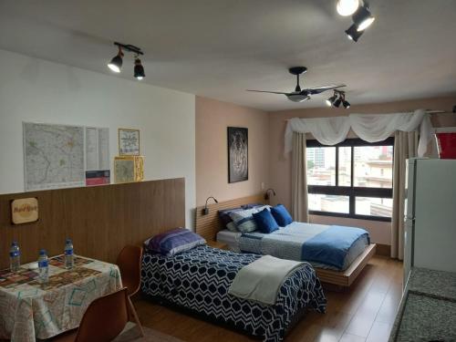 1 Schlafzimmer mit 2 Betten, einem Tisch und einem Fenster in der Unterkunft Lindo Apartamento na Frei Caneca in São Paulo