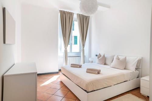 um quarto branco com uma cama e uma janela em Modern apartment in the heart of the city center em Gênova