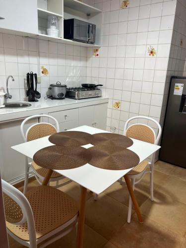 una cocina con una mesa y sillas blancas y una encimera. en ACOGEDOR DEPA SAN MIGUEL, CON INTERNET, en Lima