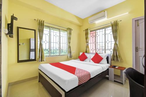 a bedroom with a bed and a mirror and windows at Hotel O Maa Residency Near Biswa Bangla in Thākurdwari