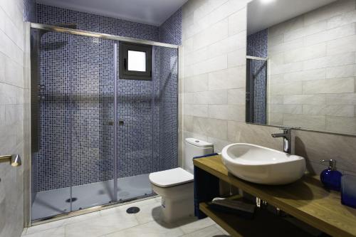 a bathroom with a toilet and a sink and a shower at Apartamentos Borizu Playa in Barro de Llanes