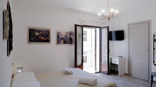 a white bedroom with a bed and a sliding glass door at Affittacamere DOMO AGORA' in Tertenìa