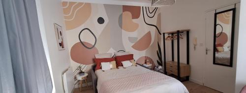 sypialnia z łóżkiem z czerwonymi poduszkami w obiekcie Studio Notre Dame coeur de ville Wifi Netflix w mieście Cholet