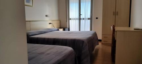 a hotel room with two beds and a window at Hotel Holiday in Giulianova