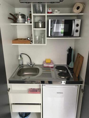 a small kitchen with a sink and a microwave at Helpens Hof in Salzhausen