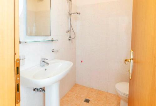 a white bathroom with a sink and a toilet at Hotel Holiday in Giulianova