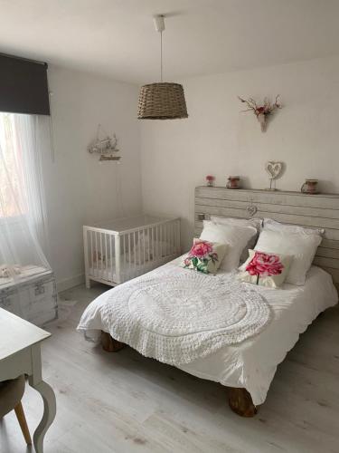 - une chambre avec un lit orné de fleurs roses dans l'établissement Villa Zen avec 2 chats, à Grospierres