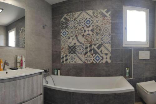une salle de bain avec une baignoire, un lavabo et des toilettes dans l'établissement Maison familiale avec piscine 7 personnes, à Cassis