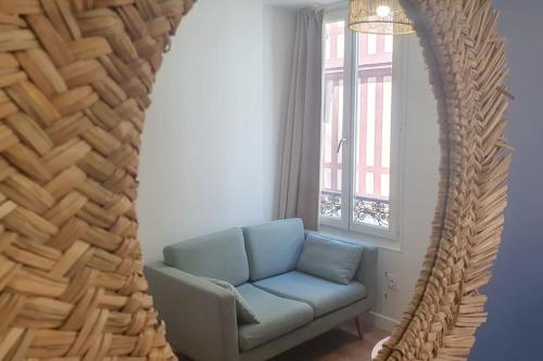 un salon avec un canapé bleu et une fenêtre dans l'établissement Studio palais de justice, à Rouen