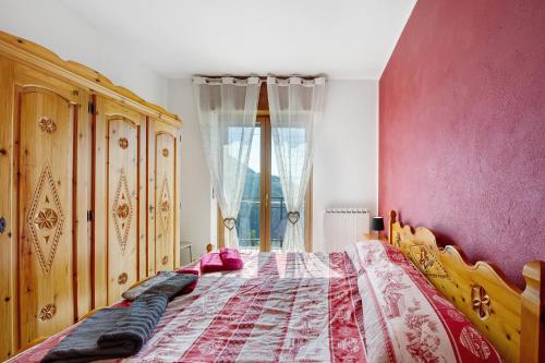 een slaapkamer met een bed en een roze muur bij Il piccolo nido in Aosta