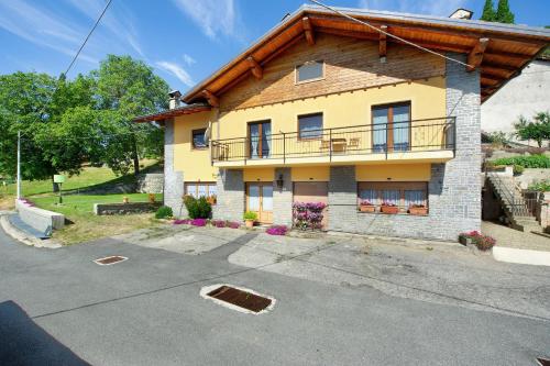 a yellow house with a balcony on top of it at Il piccolo nido in Aosta
