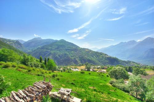 a green field with mountains in the background at Il piccolo nido in Aosta