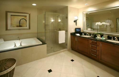 MGM Signature PH 30th floor Deluxe Studio apartment Strip Facing with Balcony في لاس فيغاس: حمام مع حوض استحمام ودش ومغسلة