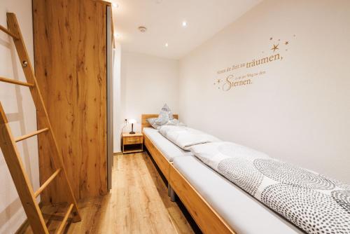 eine Reihe von Betten in einem Zimmer mit einer Wand in der Unterkunft Ferienwohnung Schuhbeck in Ruhpolding