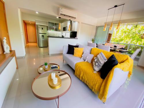 a living room with a yellow couch and a table at Apart-Hotel de Lujo en Eje Corporativo de Asunción! 2 y 3 habitaciones in Asunción