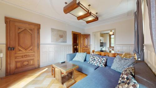 a living room with a blue couch and a table at Architectural gem with vintage charm in La Chaux-de-Fonds