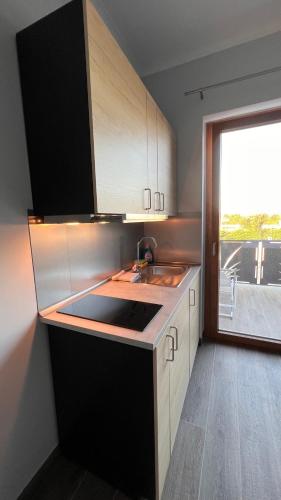 a kitchen with white cabinets and a sink and a window at Albatros Accommodations in Viterbo